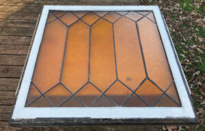 Stained glass panel in window sash before restoration