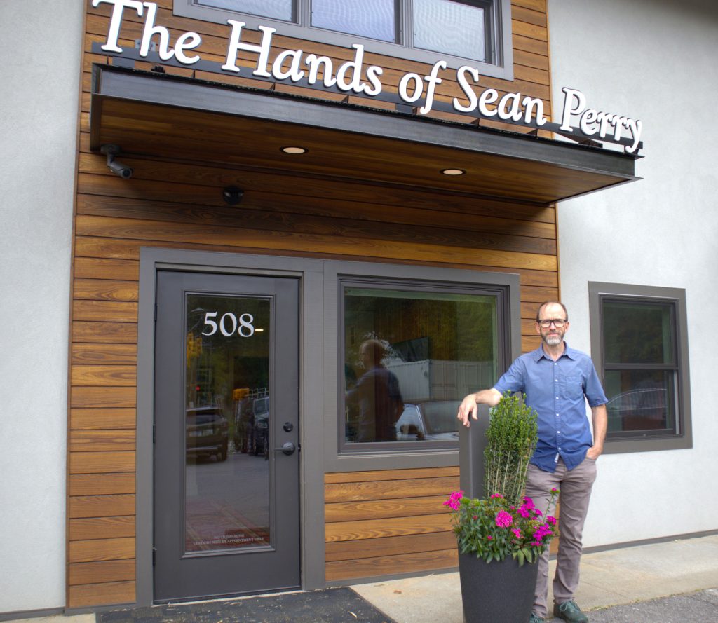 Sean Perry standing outside the door of the new Hands of Sean Perry office