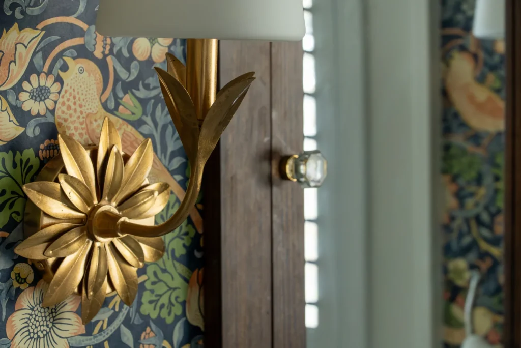 William Morris’s iconic "Strawberry Thief" wallpaper design in its original colorway, paired with Crystorama Broche sconces.