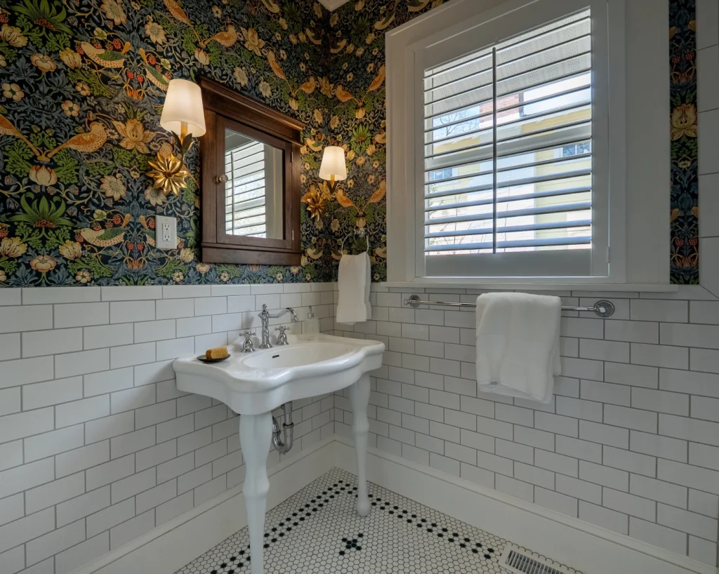 Asheville bathroom remodel by The Hands of Sean Perry. Wallpaper is William Morris’s iconic "Strawberry Thief" design in its original colorway.