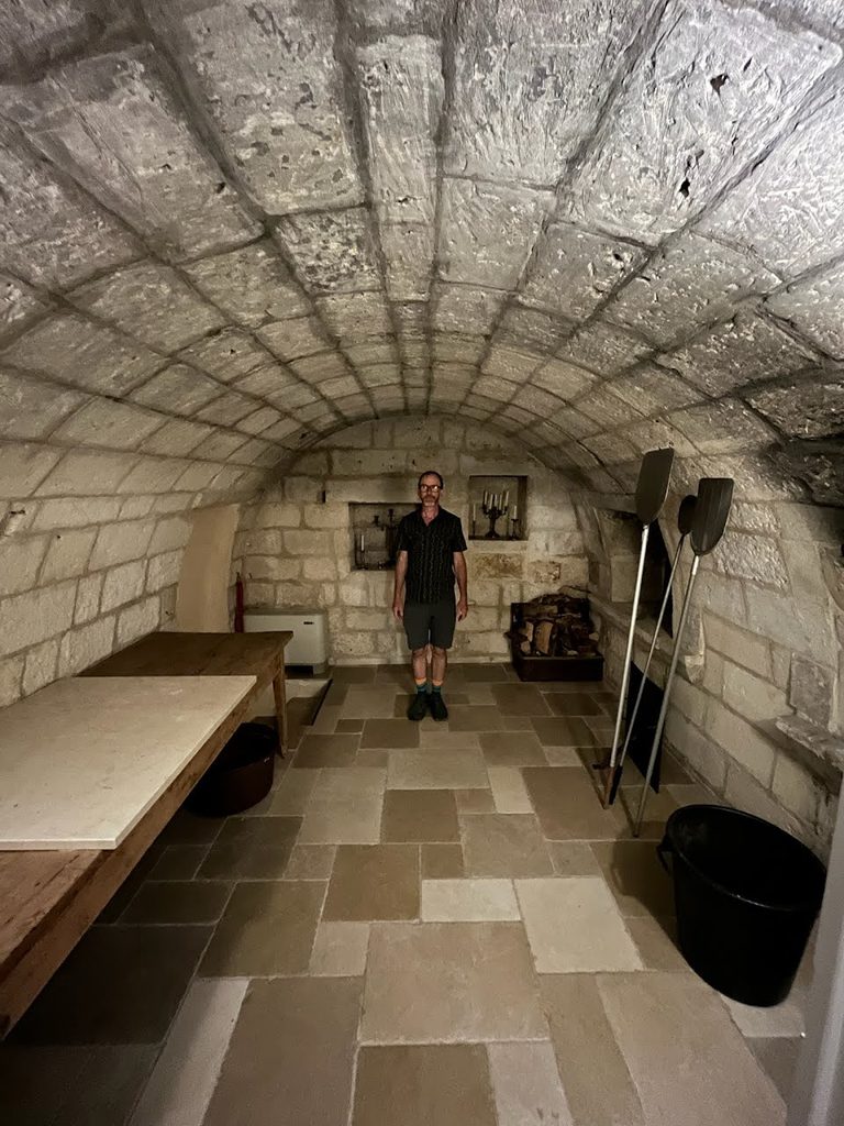 Sean Perry standing in the ancient pizza room with stone salt ovens in Palazzo Ducale Venturi.